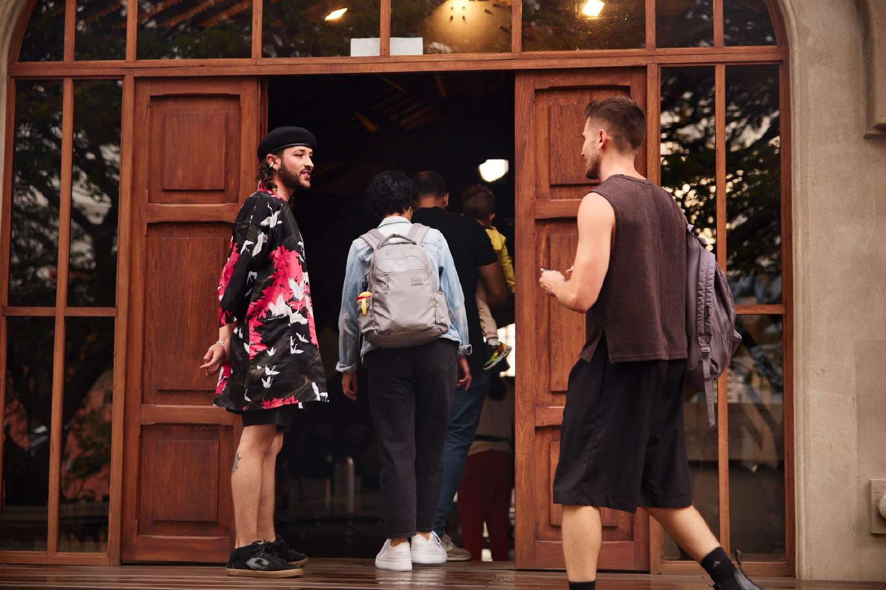 Friends walking into a venue through wooden doors