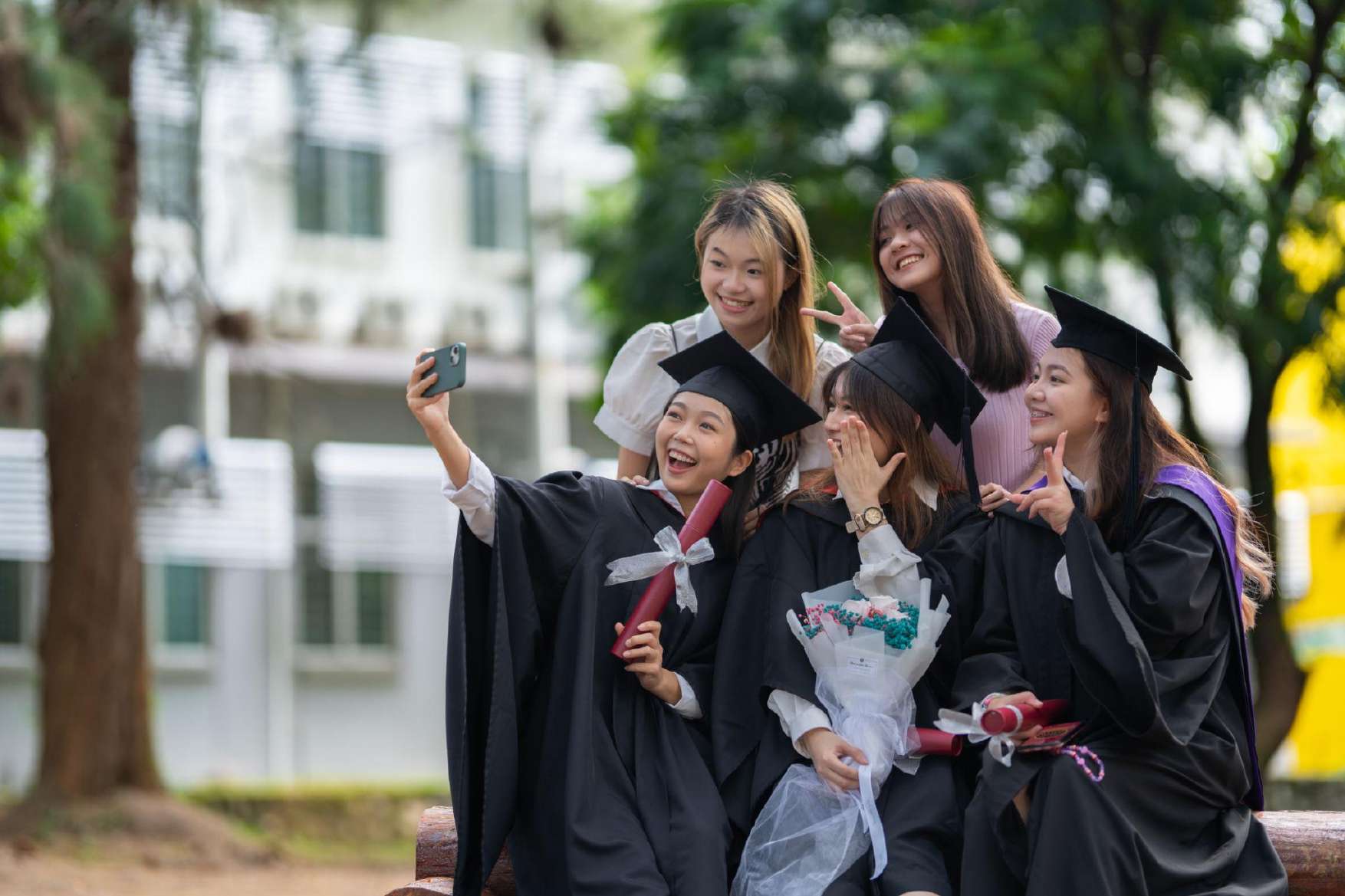 Graduates taking a selfie in their gowns